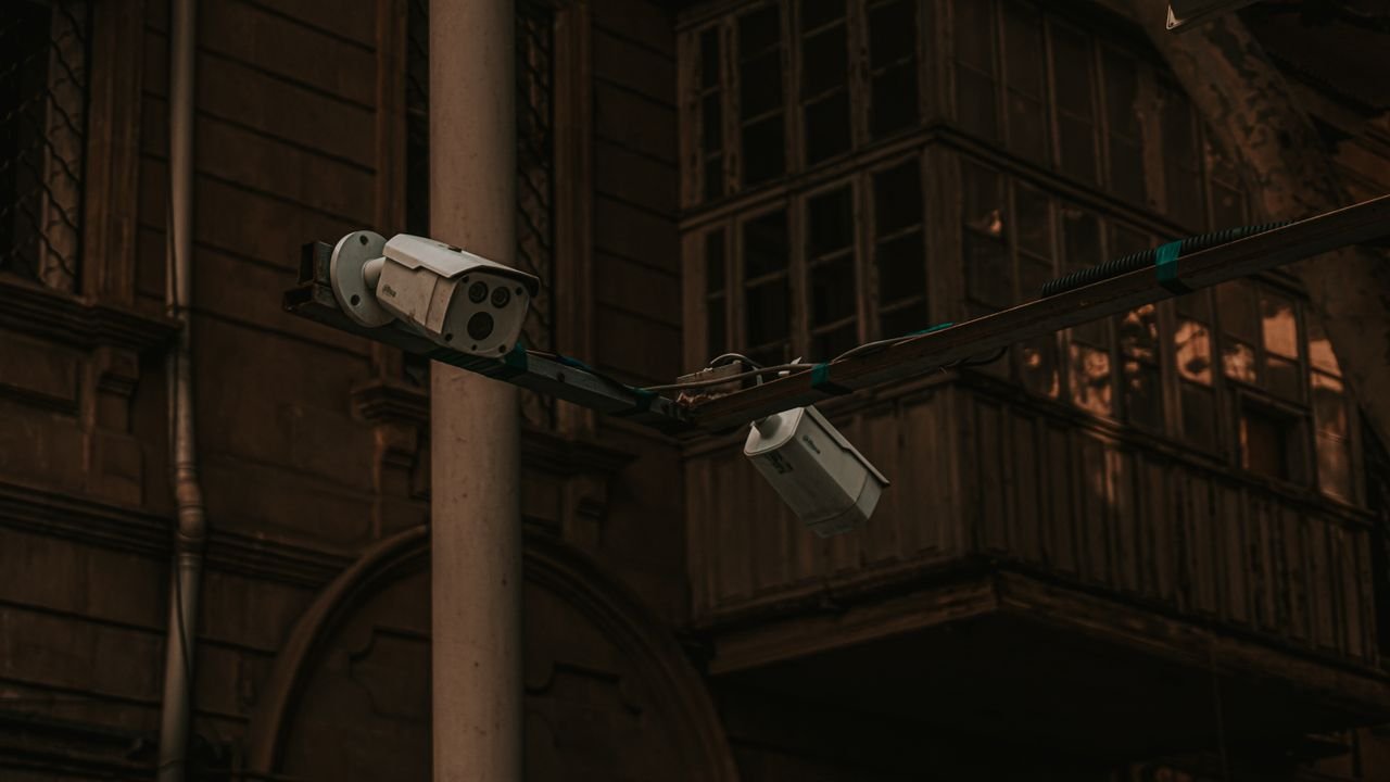 creative-03 Street security cameras mounted on a pole in an urban environment, highlighting surveillance.
